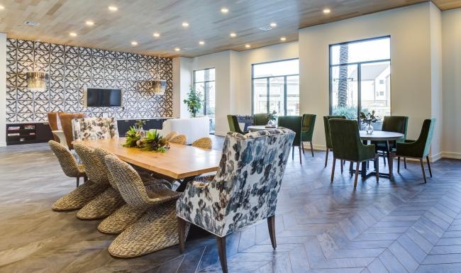 a clubroom with tables, chairs and a tv