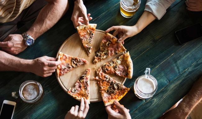 a group of people eating pizza